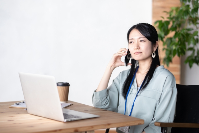 女性が嫌な顔しながら電話する